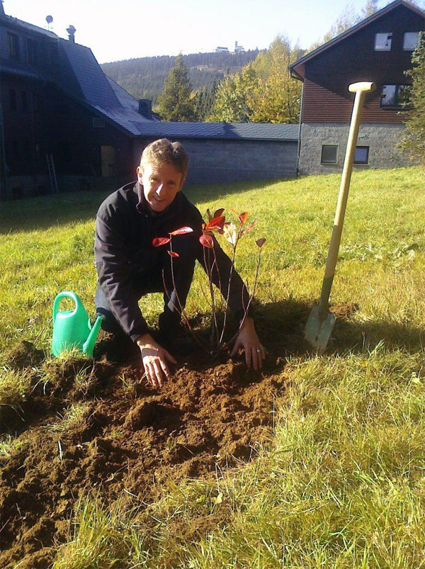 Jens Weißflog pflanzt unsere Aroniapflanze in seinen Garten